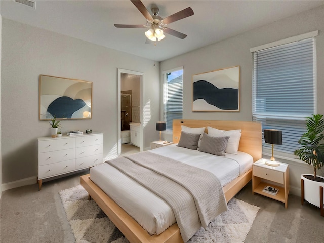 bedroom with ceiling fan, connected bathroom, carpet floors, visible vents, and baseboards