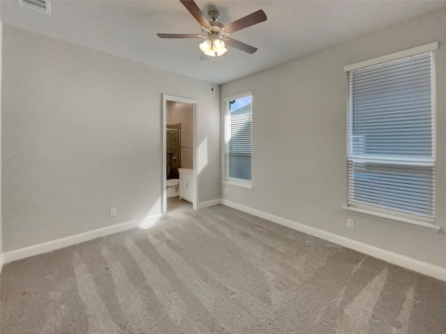 spare room with ceiling fan, carpet floors, visible vents, and baseboards