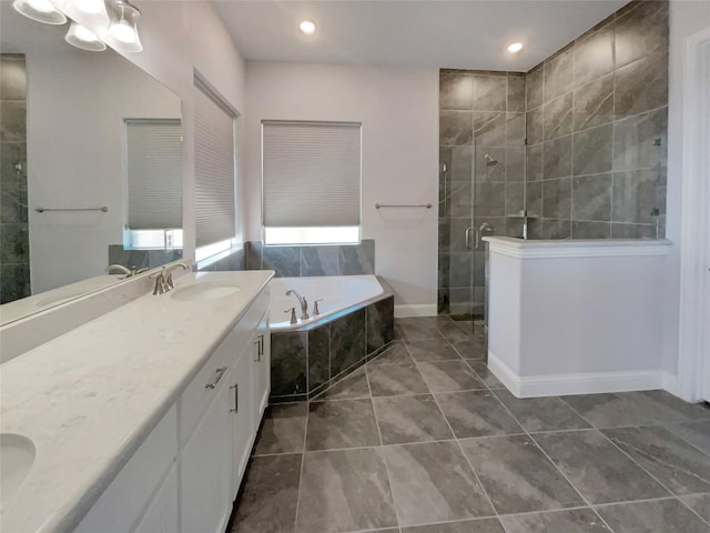 bathroom featuring double vanity, a garden tub, a tile shower, and a sink