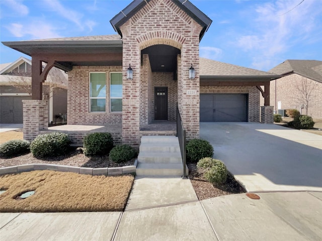 view of front of property featuring an attached garage, a porch, concrete driveway, and brick siding