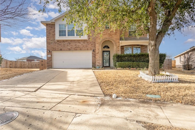 traditional home featuring an attached garage, fence, concrete driveway, and brick siding