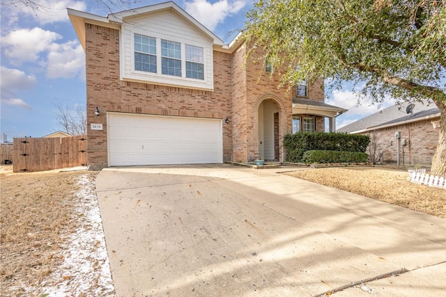 traditional-style home with driveway, an attached garage, fence, and brick siding