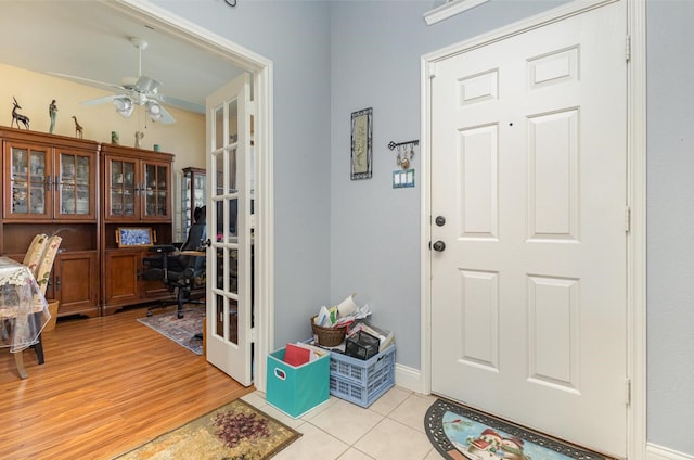 foyer with ceiling fan, light tile patterned floors, and baseboards