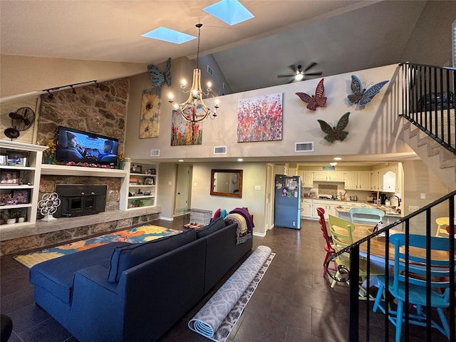 living room featuring stairs, a skylight, a fireplace, and visible vents