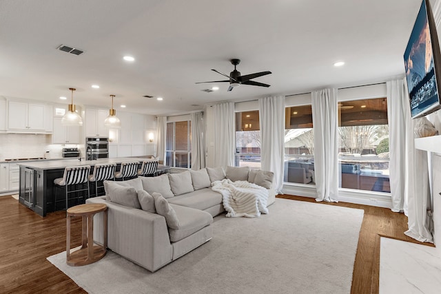 living area featuring dark wood-style floors, recessed lighting, visible vents, and ceiling fan