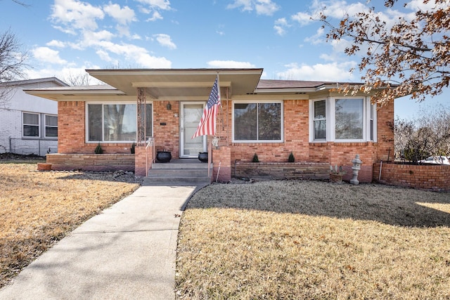 ranch-style home with a front yard and brick siding