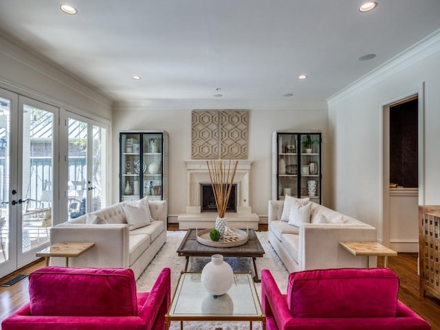 living room with ornamental molding, a premium fireplace, and wood finished floors