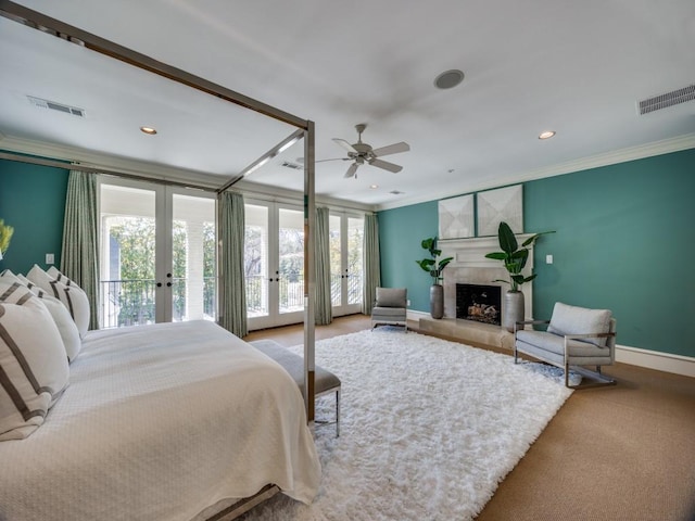 bedroom featuring visible vents, access to exterior, french doors, a tiled fireplace, and crown molding