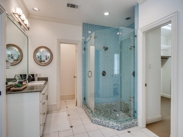 bathroom with visible vents, baseboards, ornamental molding, vanity, and a shower stall