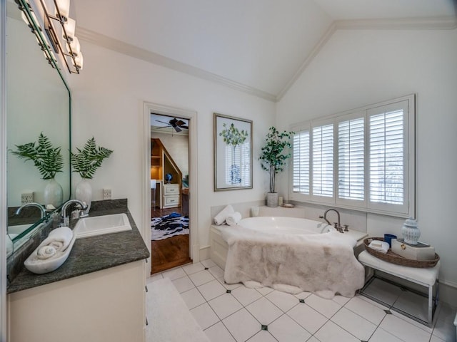 ensuite bathroom featuring connected bathroom, lofted ceiling, ornamental molding, a garden tub, and vanity