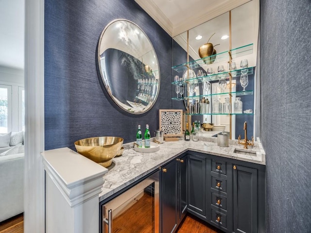 bar with beverage cooler, wet bar, crown molding, and a sink