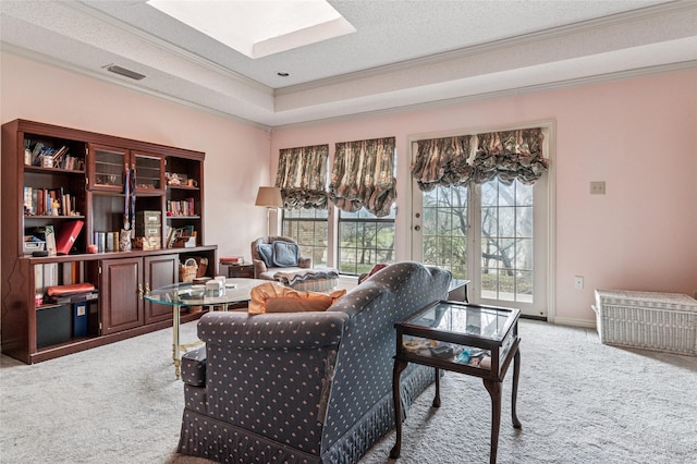 living area featuring light carpet, a skylight, visible vents, and ornamental molding