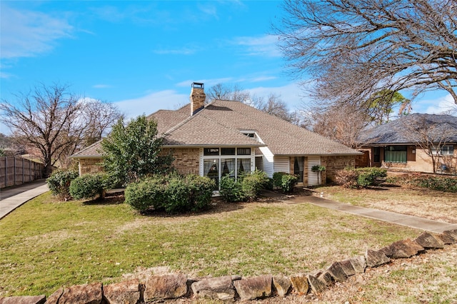 view of front facade with a chimney, fence, and a front yard