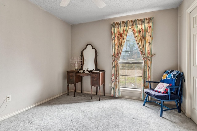 living area featuring carpet, ceiling fan, a textured ceiling, and baseboards