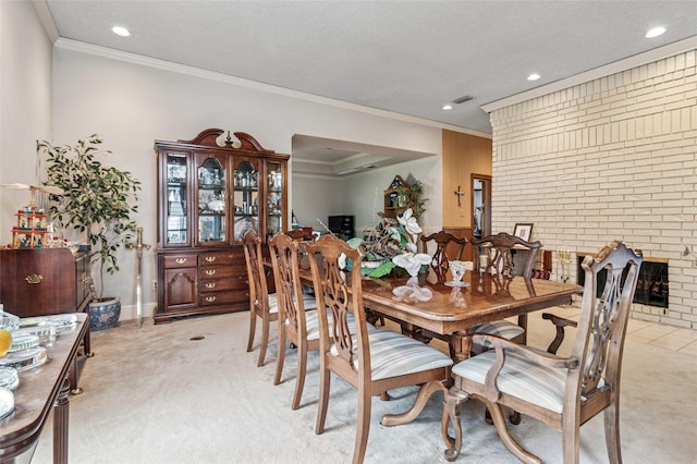 dining room with ornamental molding, light colored carpet, and a textured ceiling