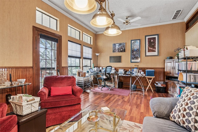 home office with a textured ceiling, wainscoting, and crown molding