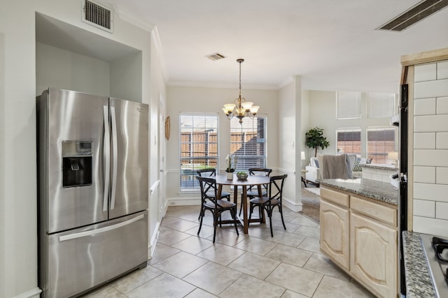 kitchen featuring stainless steel fridge, visible vents, and pendant lighting