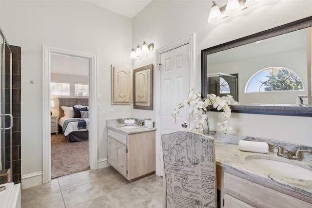 ensuite bathroom with a sink, two vanities, ensuite bath, and tile patterned floors