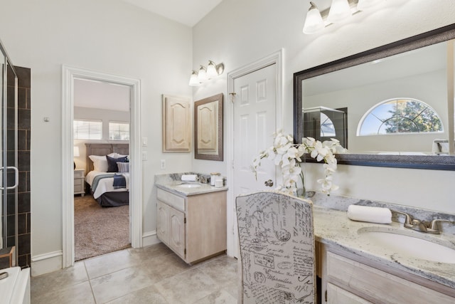 ensuite bathroom with tile patterned flooring, ensuite bath, two vanities, and a sink