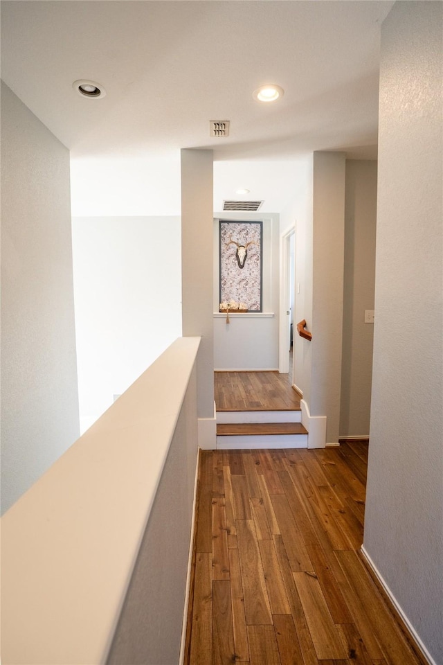 hallway featuring dark wood-style floors, visible vents, and recessed lighting