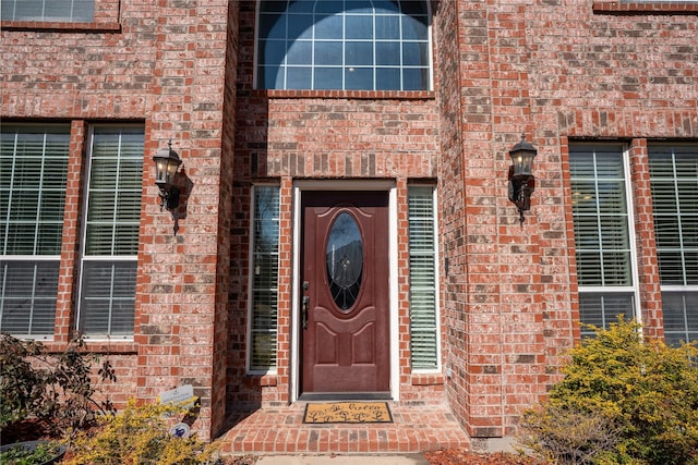 view of exterior entry with brick siding