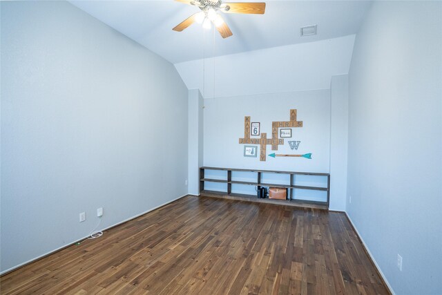 spare room featuring dark wood-style floors, ceiling fan, visible vents, and vaulted ceiling