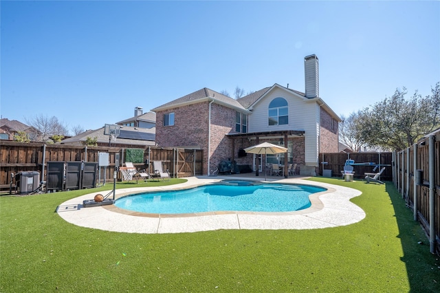 view of swimming pool featuring a pool with connected hot tub, a fenced backyard, and a lawn