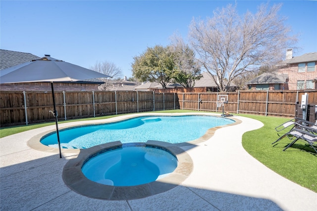 view of pool with a fenced backyard, a pool with connected hot tub, and a lawn