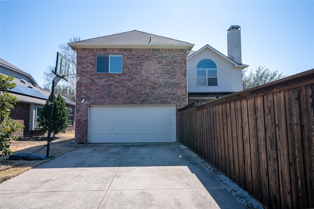 exterior space featuring concrete driveway, brick siding, a chimney, and an attached garage