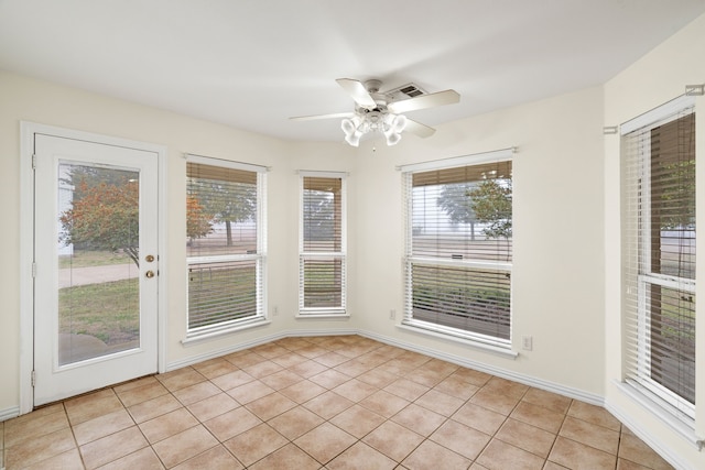 unfurnished sunroom featuring ceiling fan