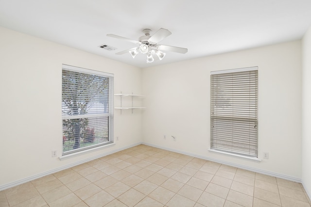 empty room featuring baseboards, visible vents, and a ceiling fan