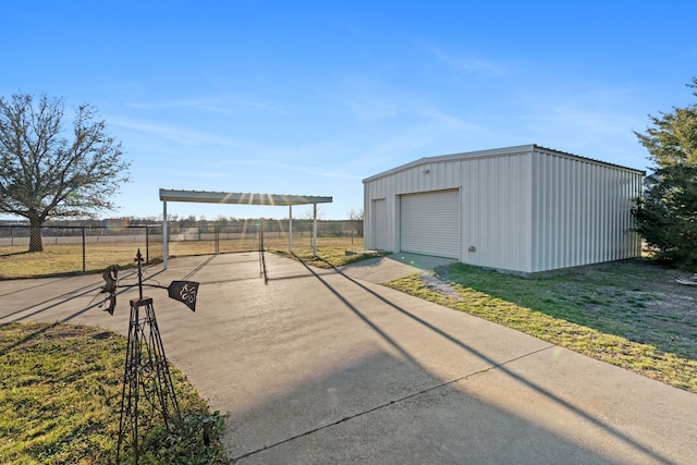 exterior space featuring an outbuilding, driveway, a rural view, and fence