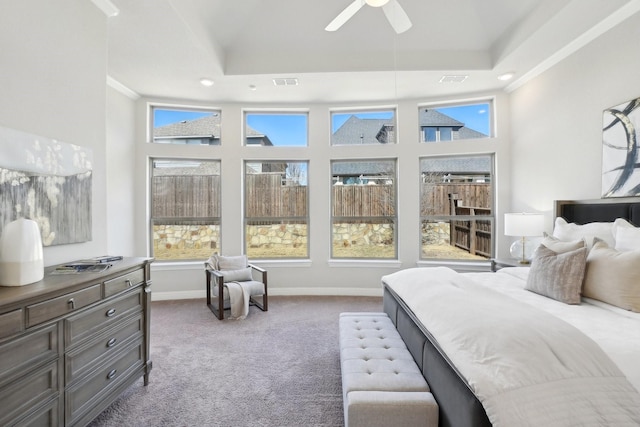 bedroom featuring a tray ceiling, baseboards, ceiling fan, and carpet