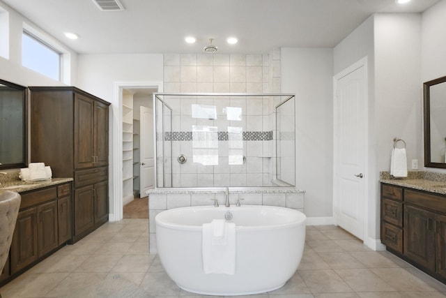 full bath with a stall shower, tile patterned floors, a freestanding bath, vanity, and a closet