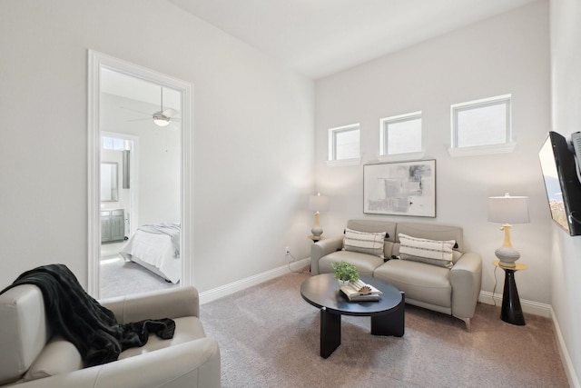 living room with light carpet, a ceiling fan, and baseboards