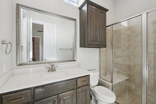 bathroom featuring toilet, a stall shower, and vanity