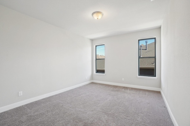 carpeted empty room featuring baseboards