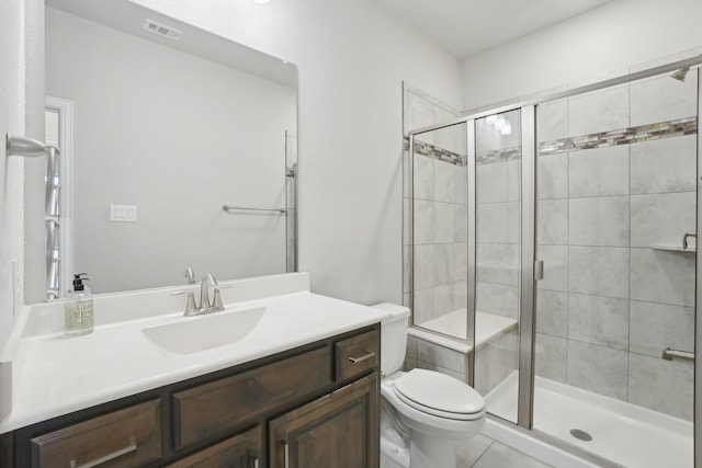 bathroom featuring visible vents, toilet, vanity, and a shower stall