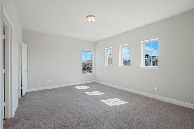 unfurnished room with light colored carpet and baseboards