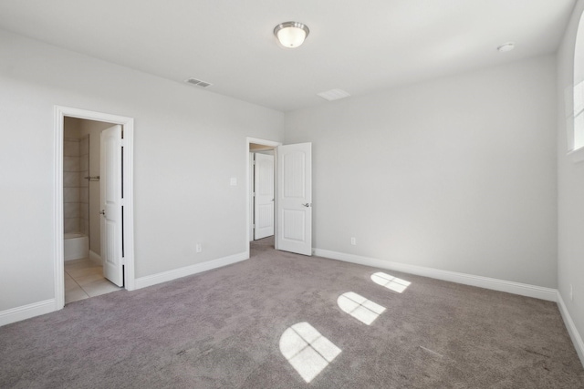 unfurnished bedroom with light colored carpet, ensuite bath, visible vents, and baseboards