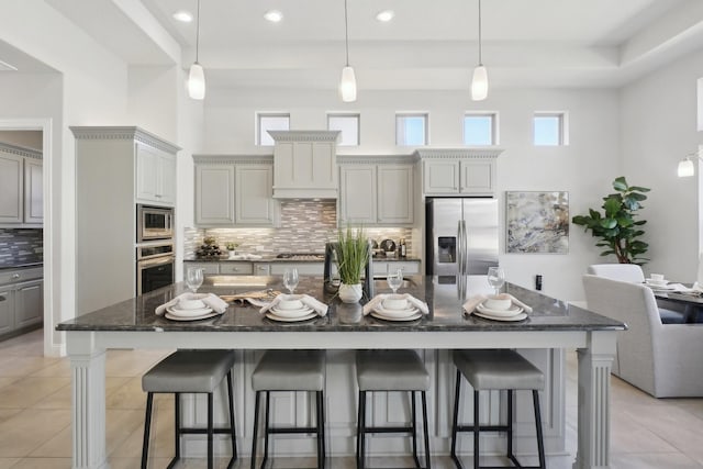 kitchen featuring stainless steel appliances, a breakfast bar, and a large island with sink