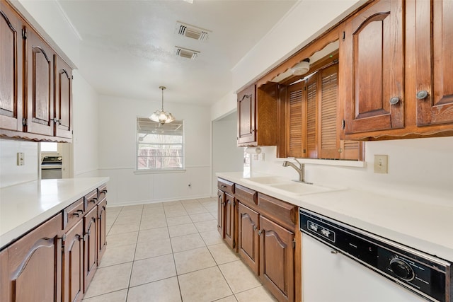 kitchen with dishwasher, wainscoting, hanging light fixtures, light countertops, and a sink