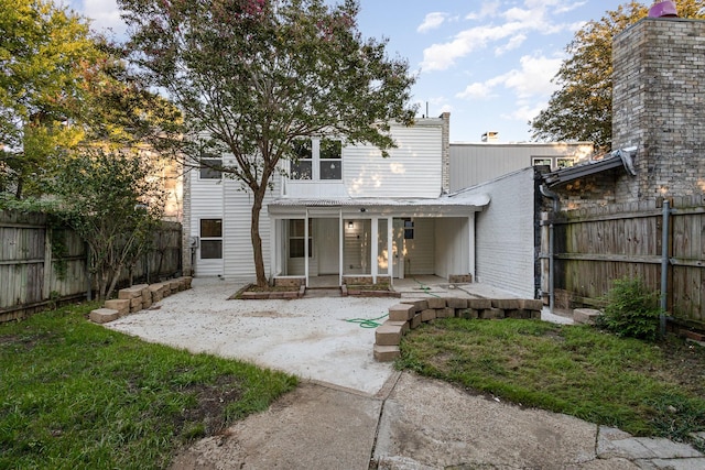 back of property featuring a lawn, a patio area, and a fenced backyard