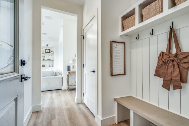 mudroom featuring light wood-style floors and baseboards