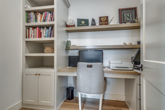 office featuring light wood-style flooring and built in desk