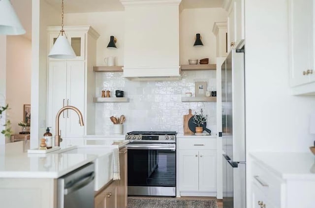 kitchen featuring appliances with stainless steel finishes, light countertops, hanging light fixtures, and open shelves