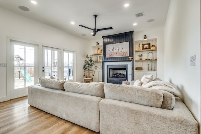 living room with recessed lighting, a large fireplace, wood finished floors, a ceiling fan, and visible vents