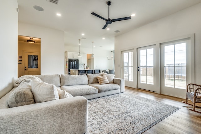 living room featuring a ceiling fan, light wood-type flooring, and recessed lighting