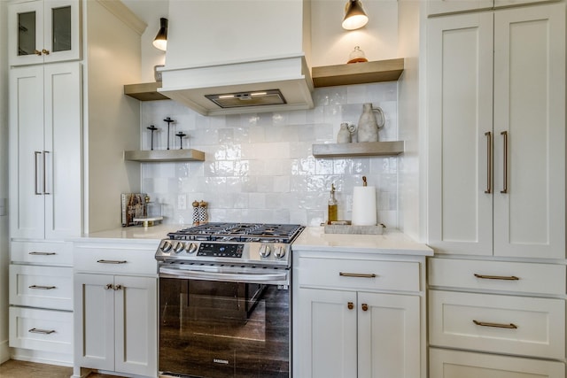 kitchen featuring tasteful backsplash, gas range, glass insert cabinets, white cabinetry, and open shelves