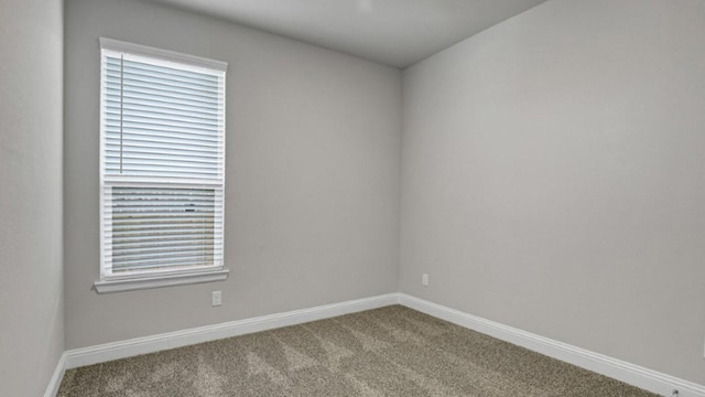 empty room featuring baseboards and carpet flooring